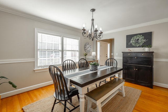 dining area featuring a chandelier, light hardwood / wood-style floors, and ornamental molding