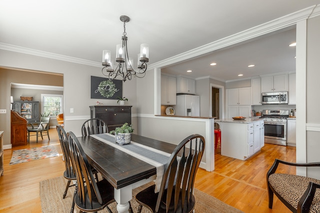 dining area featuring light hardwood / wood-style floors, ornamental molding, and a notable chandelier