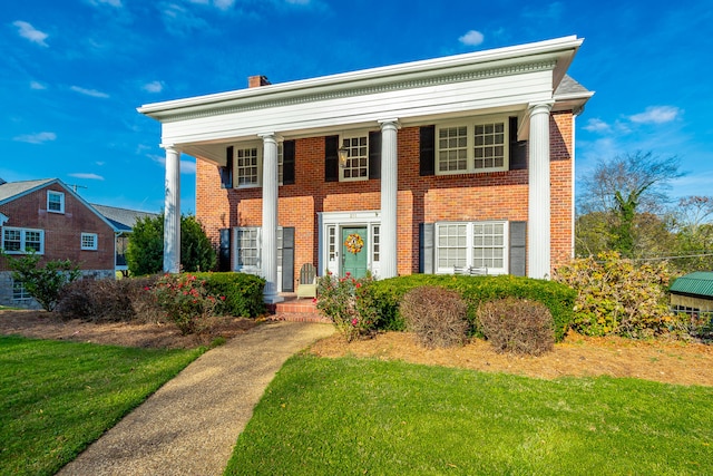 greek revival house featuring a front lawn