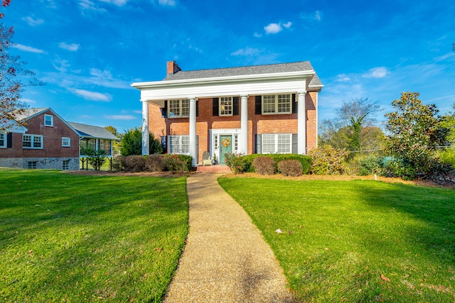 neoclassical / greek revival house featuring a front lawn