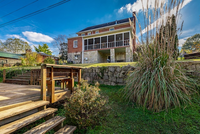 back of house featuring a sunroom and a deck