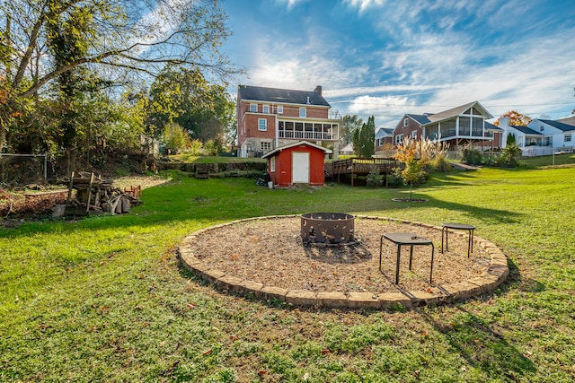 view of yard with an outdoor fire pit, a storage shed, and a wooden deck