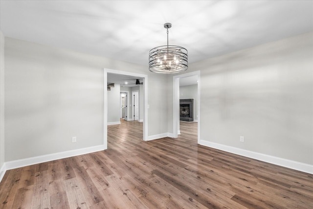 unfurnished living room with hardwood / wood-style flooring and a chandelier