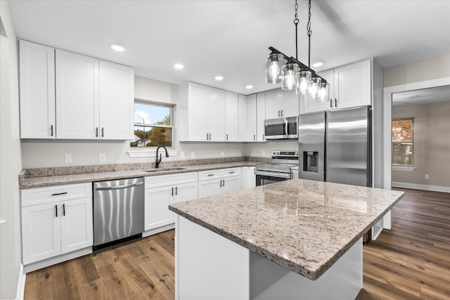 kitchen featuring dark hardwood / wood-style floors, a kitchen island, white cabinetry, and stainless steel appliances