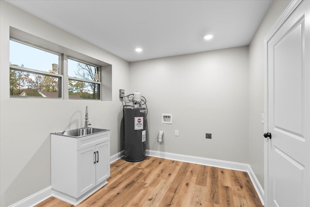 laundry area featuring cabinets, electric water heater, washer hookup, light wood-type flooring, and hookup for an electric dryer