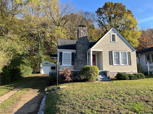 view of front of home with a garage, an outdoor structure, and a front lawn