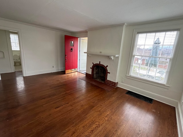 unfurnished living room featuring a textured ceiling, dark hardwood / wood-style flooring, crown molding, and a brick fireplace