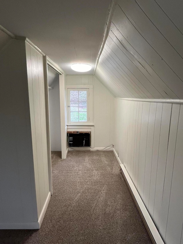 bonus room with wood walls, vaulted ceiling, a baseboard radiator, carpet floors, and a wall unit AC