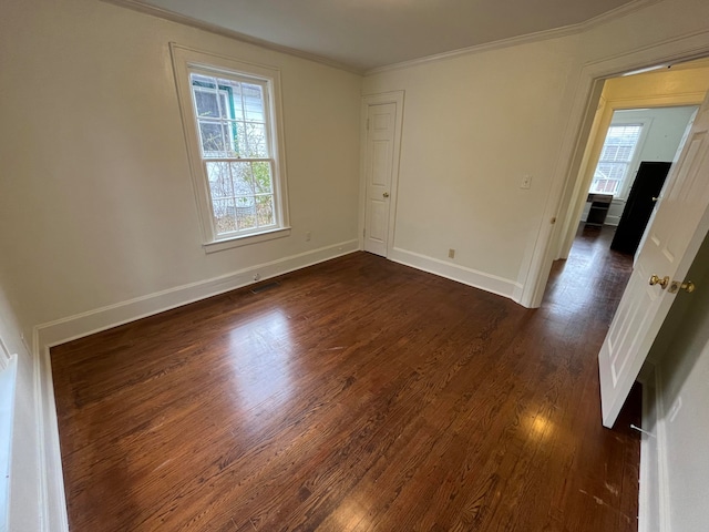 spare room with crown molding and dark hardwood / wood-style flooring