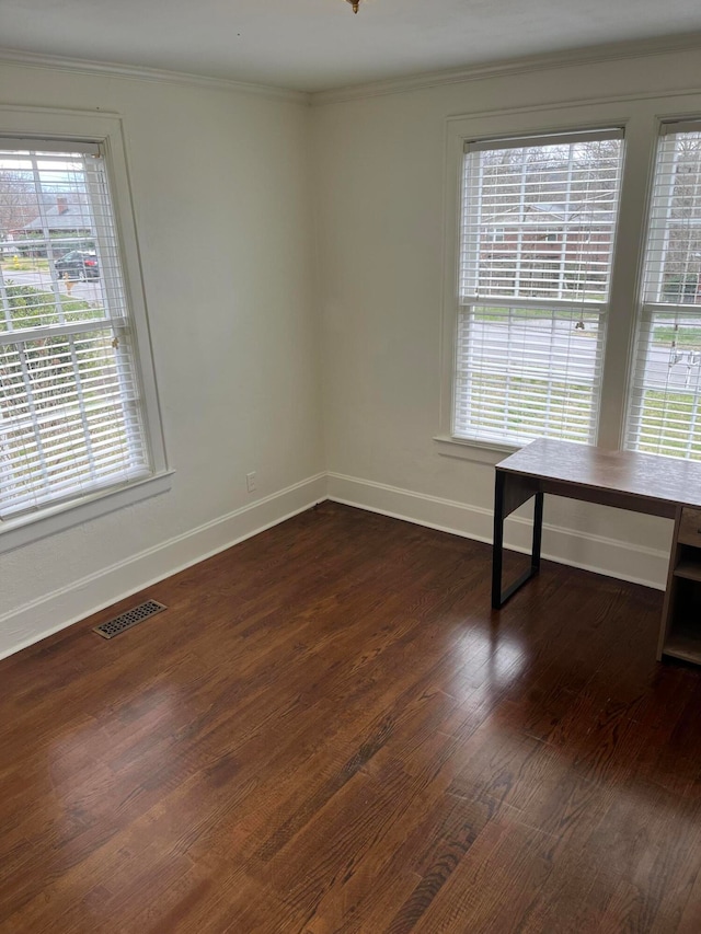 unfurnished room featuring dark hardwood / wood-style floors, a wealth of natural light, and ornamental molding