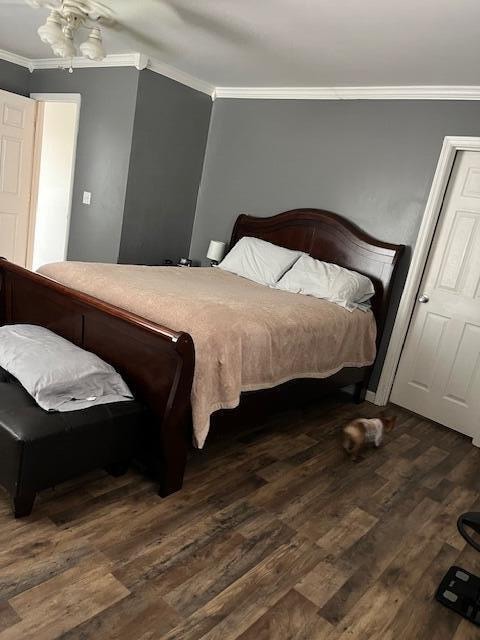 bedroom with ceiling fan, dark hardwood / wood-style floors, and ornamental molding