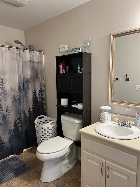 bathroom featuring walk in shower, vanity, and toilet