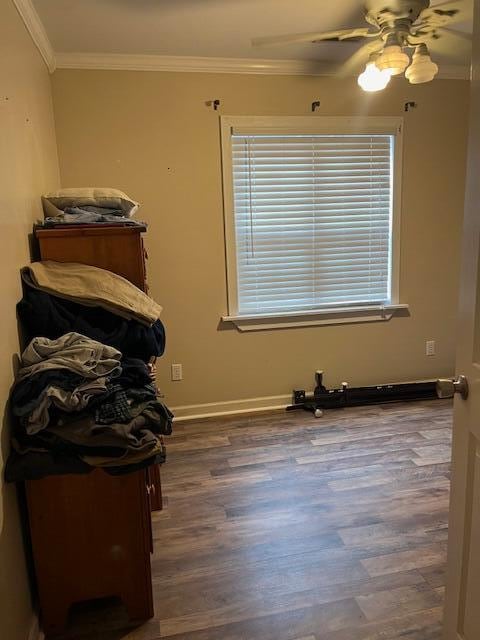 interior space with ceiling fan, dark hardwood / wood-style floors, and ornamental molding