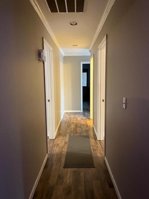 corridor with ornamental molding and dark wood-type flooring