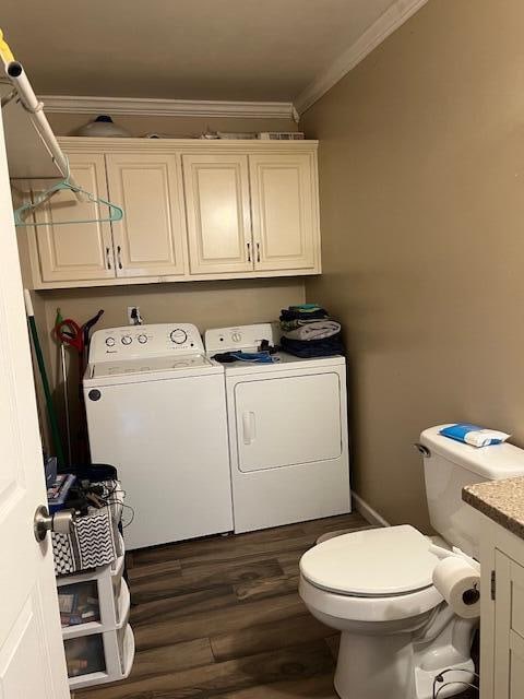 laundry area with separate washer and dryer, dark wood-type flooring, and ornamental molding