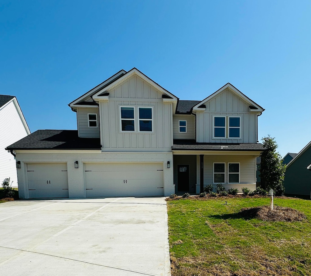 craftsman inspired home featuring a garage and a front lawn