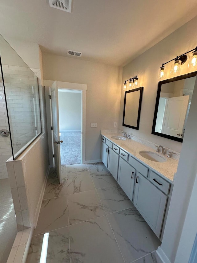 bathroom with a tile shower and vanity