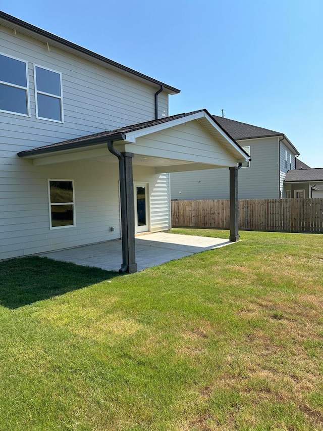 back of property with a yard and a patio area