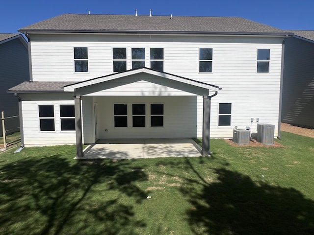 rear view of property with a patio area, a yard, and central AC