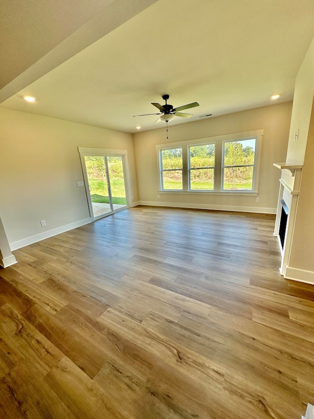 unfurnished living room featuring light wood-type flooring and ceiling fan