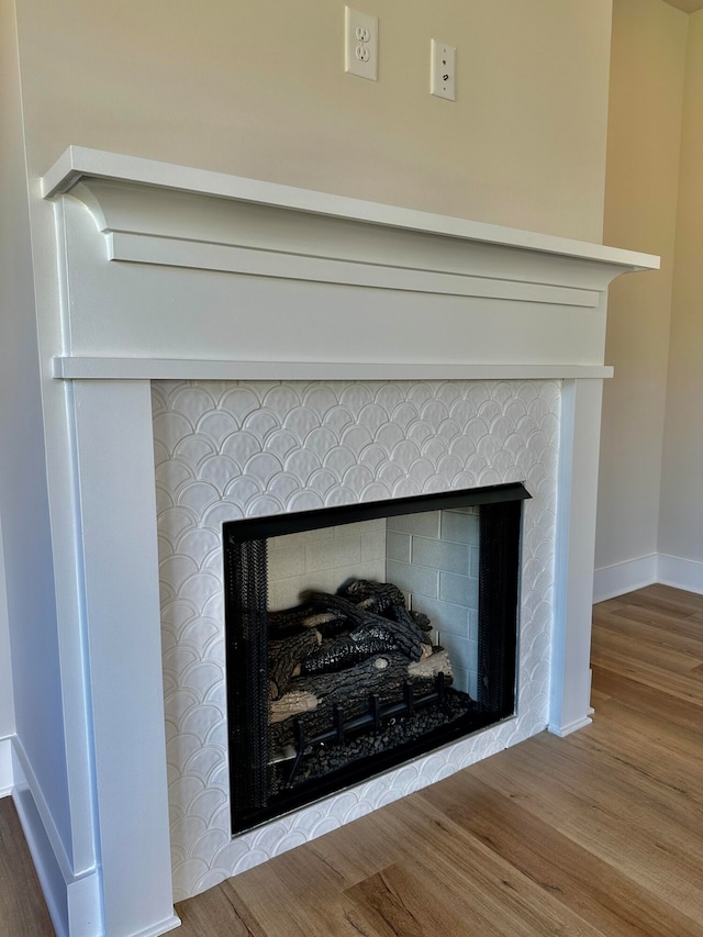 interior details with hardwood / wood-style flooring and a tiled fireplace