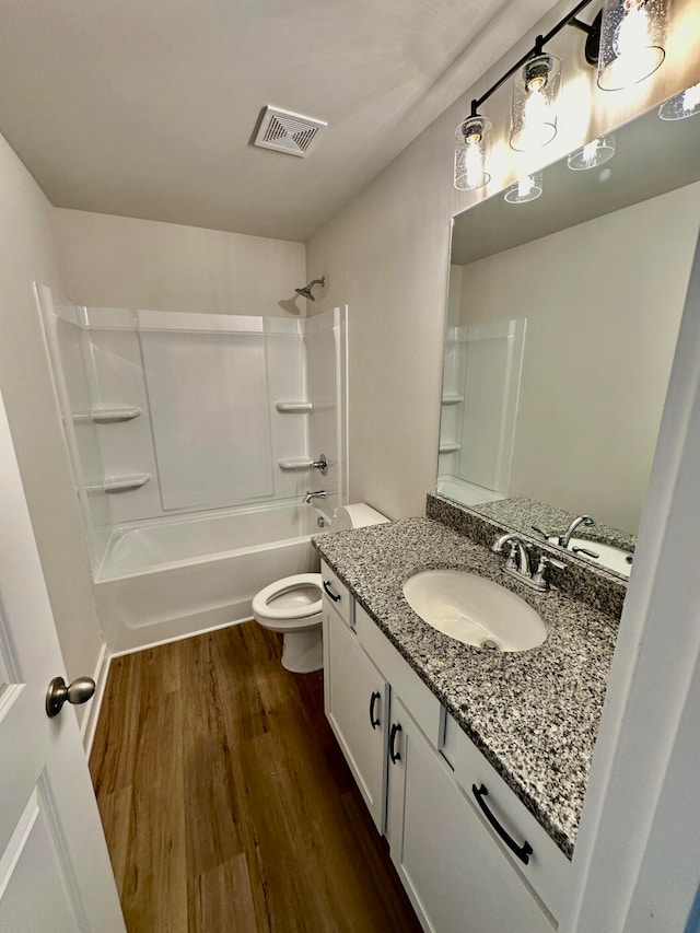 full bathroom featuring hardwood / wood-style flooring, vanity, toilet, and tub / shower combination