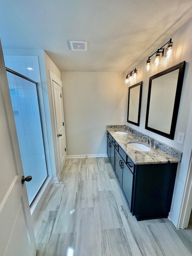 bathroom with hardwood / wood-style flooring, vanity, and a shower with shower door