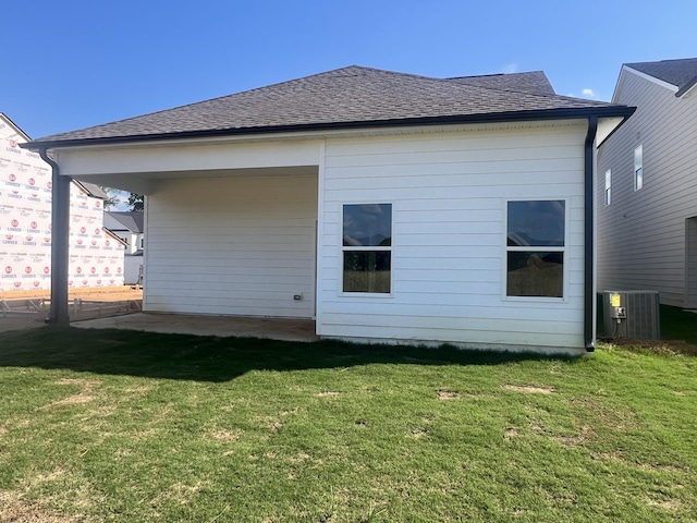 rear view of property featuring cooling unit and a yard