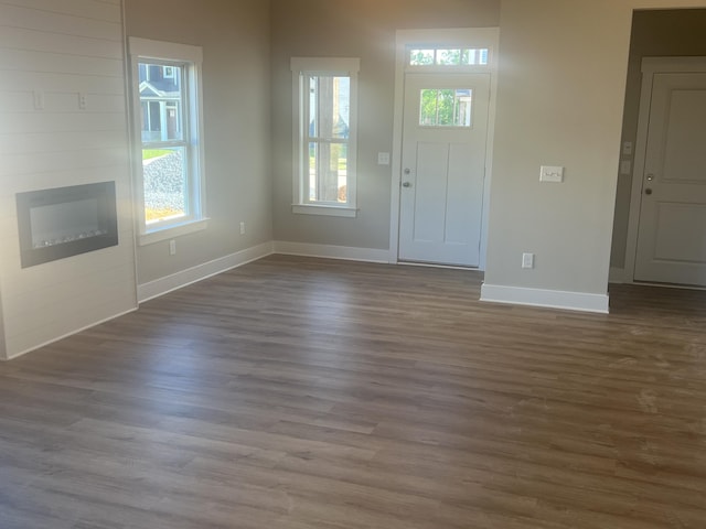 entrance foyer with wood-type flooring and a large fireplace