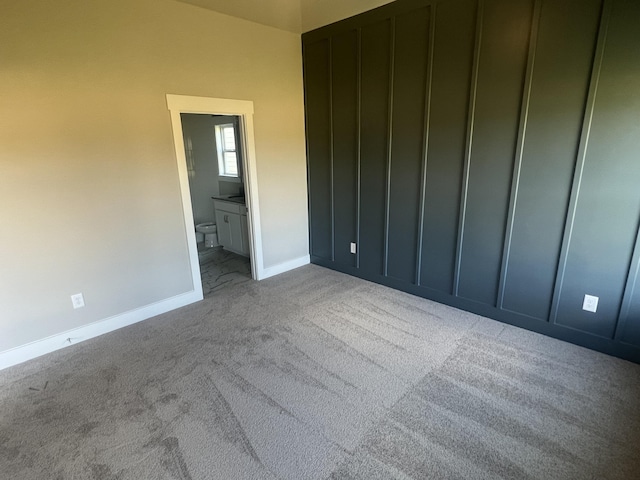 unfurnished bedroom featuring carpet and ensuite bathroom