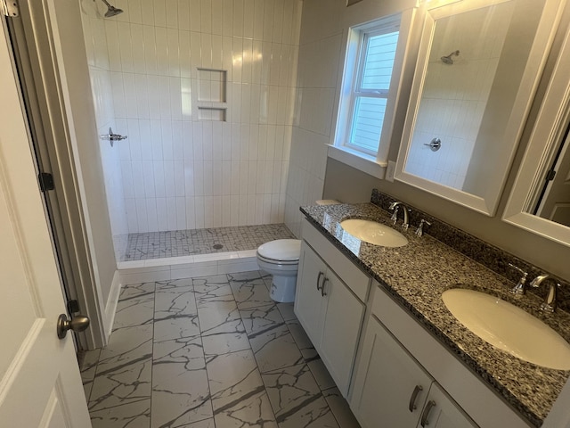 bathroom featuring tiled shower, vanity, and toilet