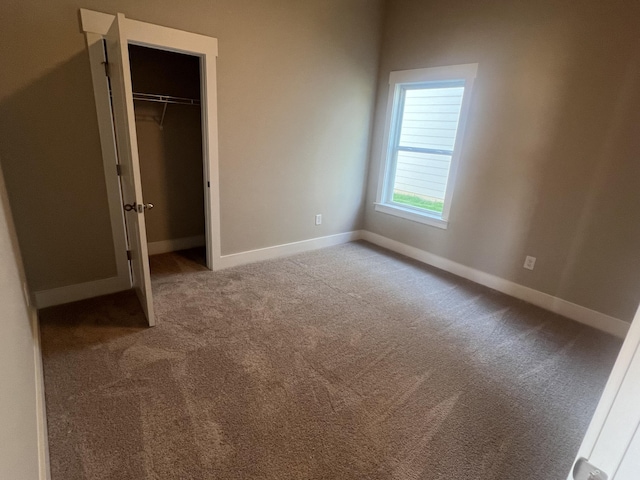 unfurnished bedroom with light colored carpet and a closet