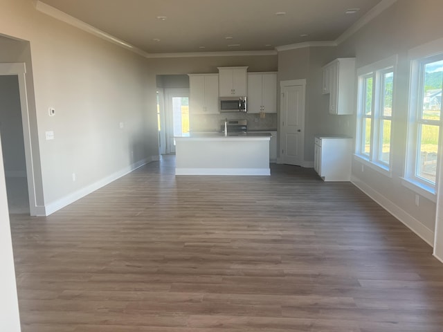 unfurnished living room with crown molding, sink, and hardwood / wood-style flooring