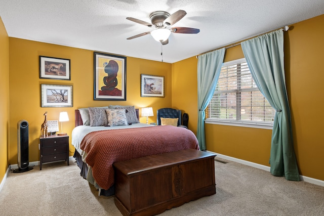 bedroom featuring ceiling fan, light colored carpet, and a textured ceiling