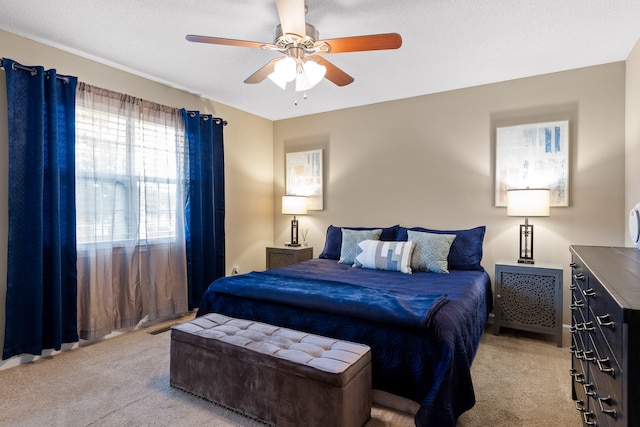 carpeted bedroom with ceiling fan and a textured ceiling