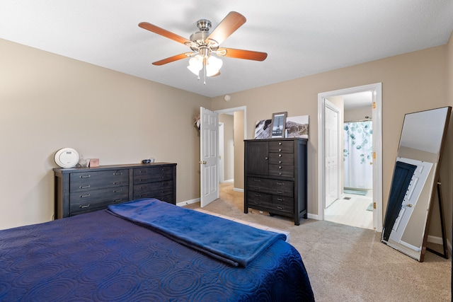 carpeted bedroom with ensuite bathroom and ceiling fan