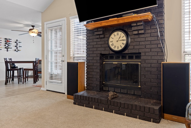 living room featuring a wealth of natural light, light colored carpet, and a brick fireplace