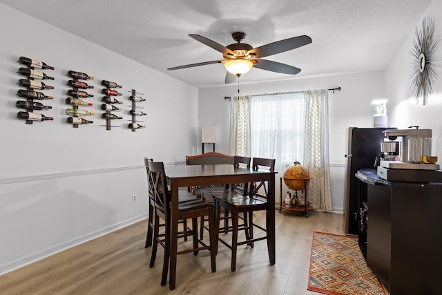 dining space featuring ceiling fan, light hardwood / wood-style floors, and a textured ceiling