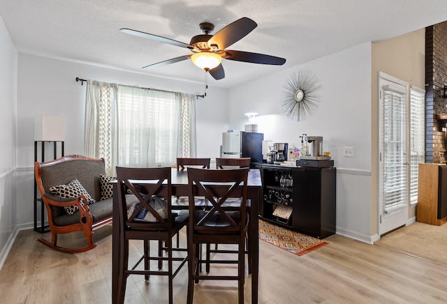 dining space with light hardwood / wood-style floors, a wealth of natural light, and ceiling fan