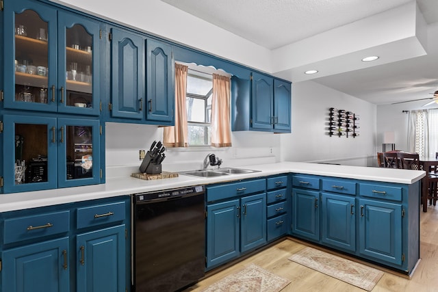 kitchen with sink, dishwasher, light wood-type flooring, and blue cabinets