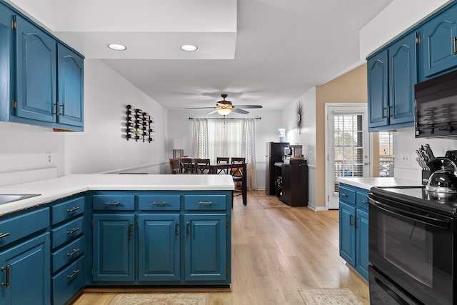 kitchen with black appliances, ceiling fan, blue cabinetry, light hardwood / wood-style floors, and kitchen peninsula