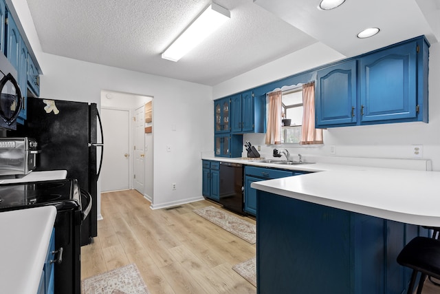 kitchen with black dishwasher, light hardwood / wood-style floors, blue cabinets, and sink