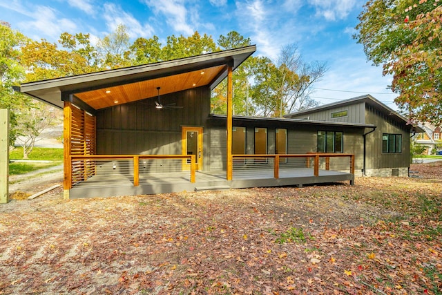 view of side of home with ceiling fan and a wooden deck