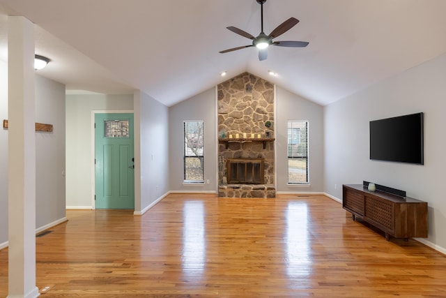 unfurnished living room featuring a fireplace, light wood-type flooring, ceiling fan, and lofted ceiling