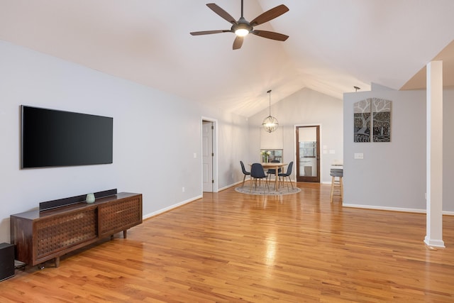 living room featuring ceiling fan with notable chandelier, vaulted ceiling, and light wood-type flooring