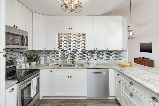 kitchen featuring appliances with stainless steel finishes, dark wood-type flooring, sink, white cabinets, and hanging light fixtures