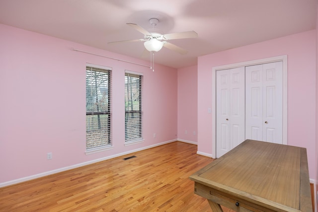 unfurnished bedroom with a closet, light hardwood / wood-style floors, and ceiling fan