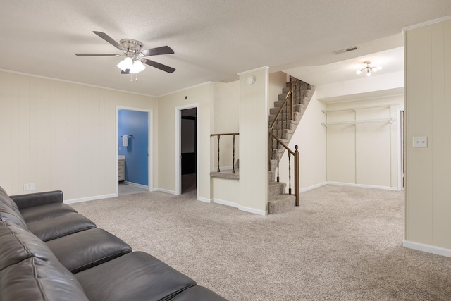 living room featuring light carpet, a textured ceiling, ceiling fan, and ornamental molding