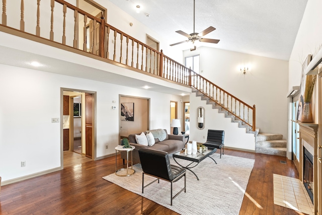 living room featuring ceiling fan, high vaulted ceiling, and dark wood-type flooring