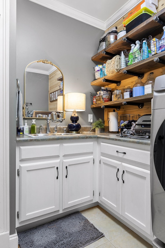 laundry area featuring sink, light tile patterned floors, and ornamental molding